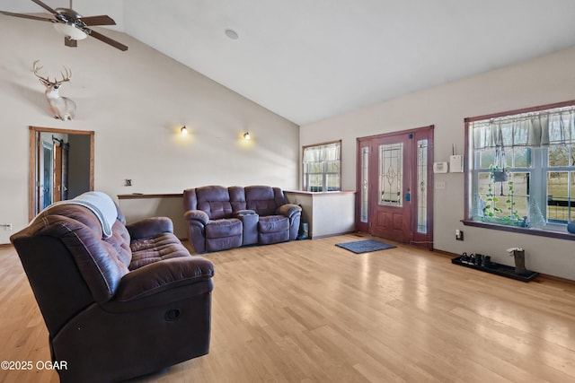 living area with ceiling fan, light wood-style floors, and high vaulted ceiling