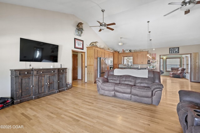 living area featuring light wood-type flooring, high vaulted ceiling, and ceiling fan