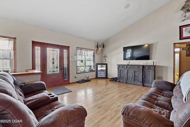 living room with high vaulted ceiling and wood finished floors