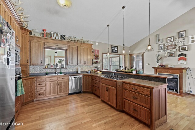 kitchen featuring a wealth of natural light, appliances with stainless steel finishes, a peninsula, and a sink