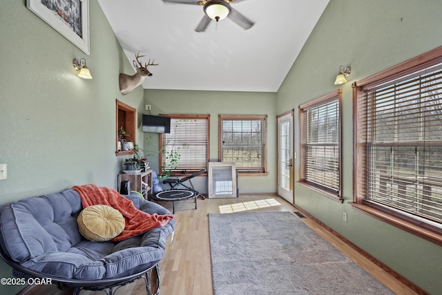 sunroom / solarium featuring visible vents, lofted ceiling, and ceiling fan