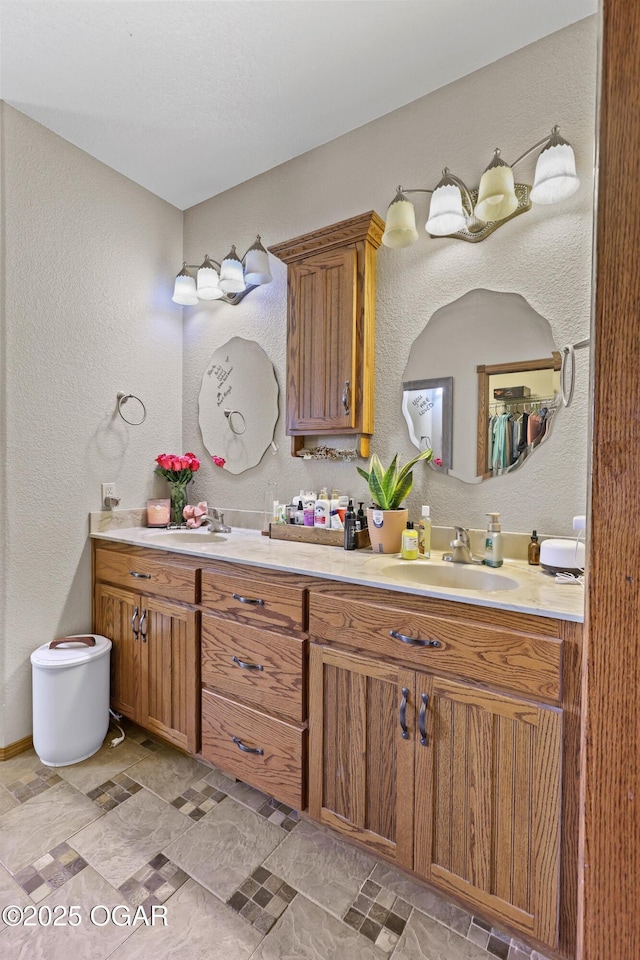 full bathroom featuring a sink, double vanity, and a textured wall