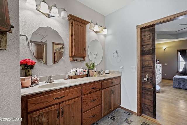 ensuite bathroom featuring a sink, baseboards, ensuite bathroom, and double vanity