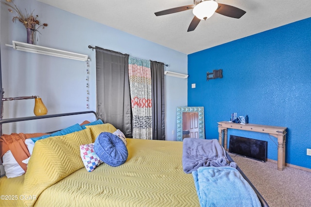 bedroom with carpet floors, a textured ceiling, a ceiling fan, and a textured wall