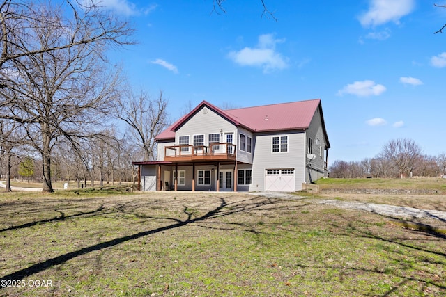 rear view of property with a lawn, french doors, metal roof, and driveway