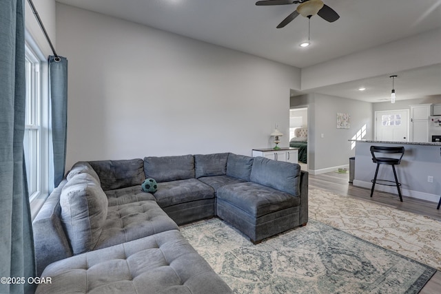 living area featuring recessed lighting, baseboards, light wood-type flooring, and ceiling fan