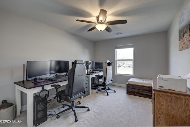 office area featuring visible vents, baseboards, carpet flooring, a textured ceiling, and a ceiling fan