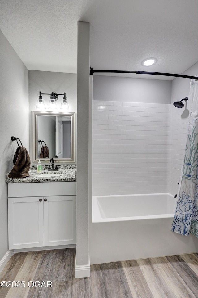 bathroom featuring vanity, a textured ceiling, shower / bath combo, and wood finished floors