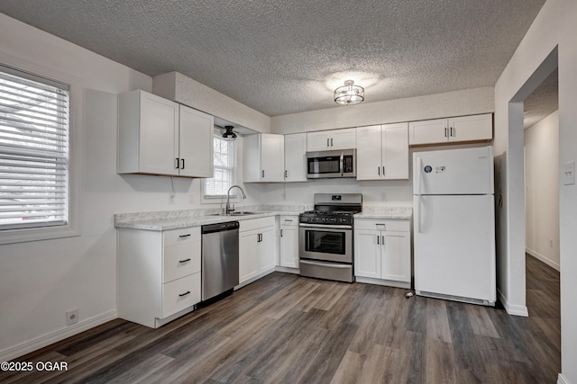 kitchen featuring a sink, white cabinets, light countertops, appliances with stainless steel finishes, and dark wood finished floors