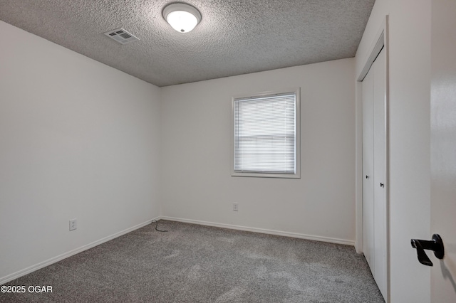 unfurnished bedroom with a closet, carpet, visible vents, and baseboards