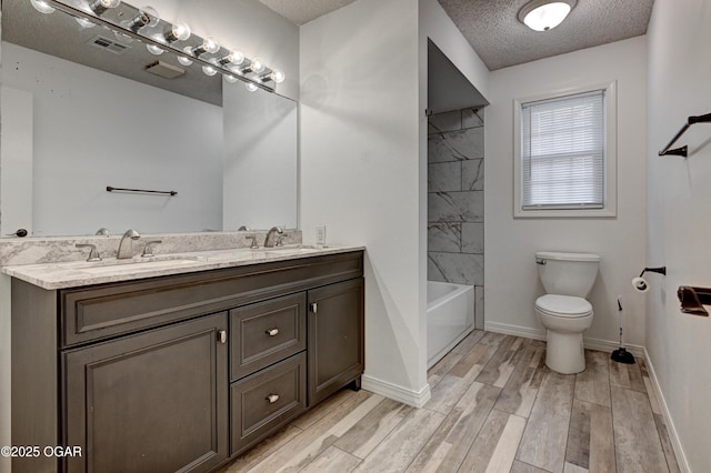 full bath with toilet, a textured ceiling, visible vents, and a sink