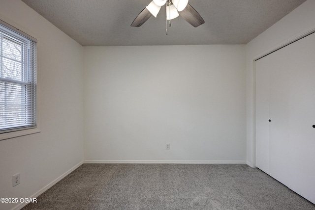 unfurnished bedroom featuring a textured ceiling, carpet flooring, a ceiling fan, baseboards, and a closet