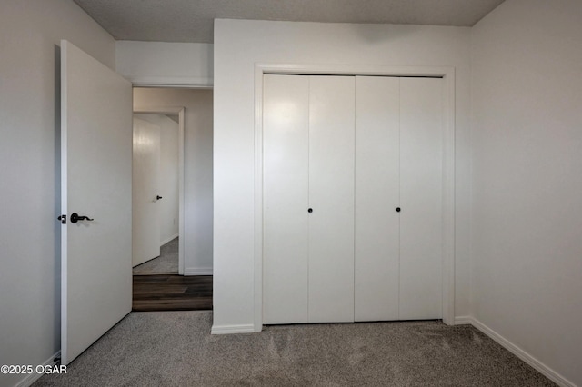 unfurnished bedroom featuring a closet, carpet flooring, and baseboards