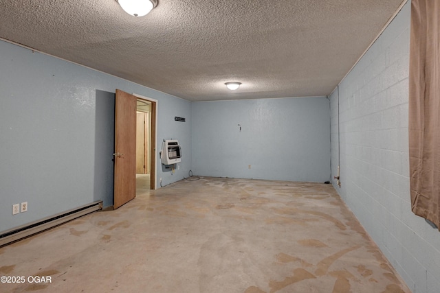 basement with heating unit, a baseboard radiator, a textured ceiling, and concrete block wall