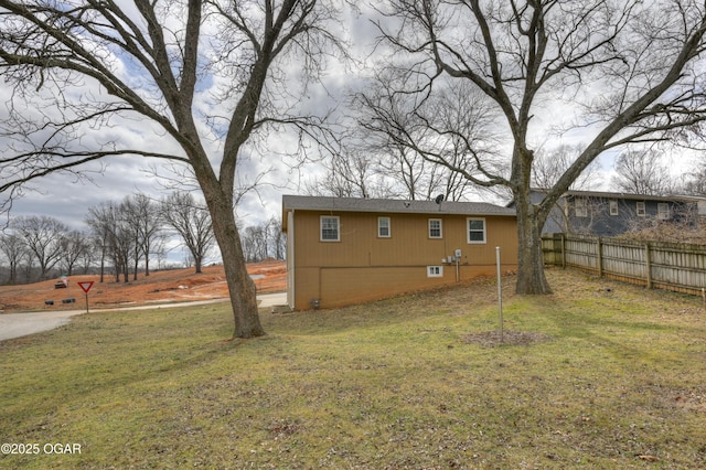 exterior space featuring a lawn and fence