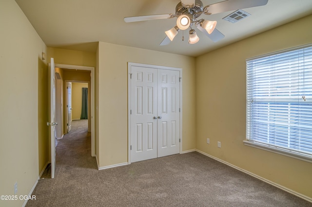 unfurnished bedroom with carpet, a closet, visible vents, and multiple windows