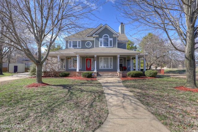 view of front of home with covered porch, roof with shingles, a chimney, and a front lawn