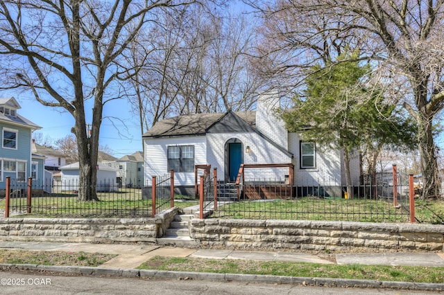 view of front of property with a fenced front yard, brick siding, and a front yard