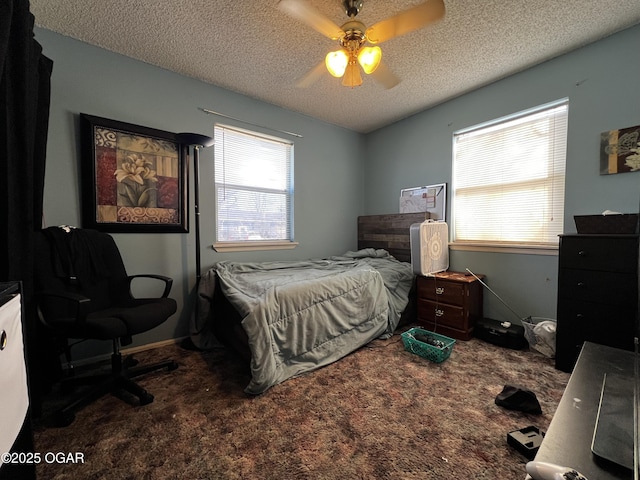 carpeted bedroom featuring ceiling fan and a textured ceiling