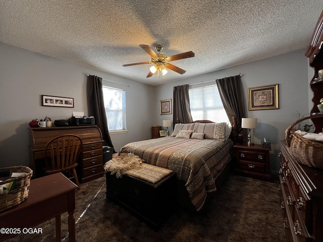 bedroom with ceiling fan, multiple windows, dark carpet, and a textured ceiling