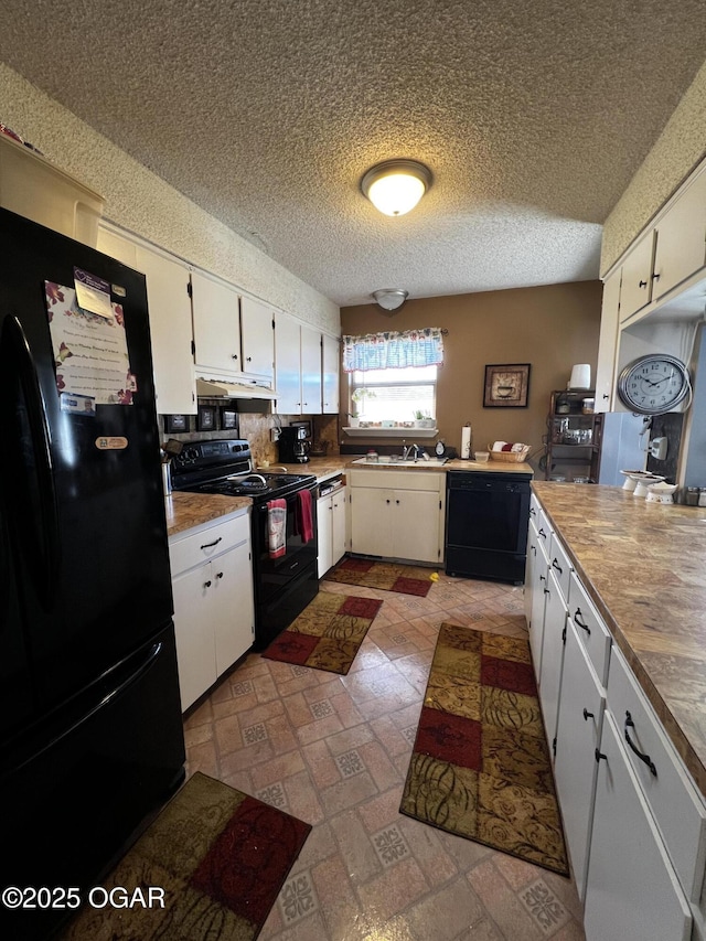 kitchen featuring white cabinetry, a sink, a textured ceiling, under cabinet range hood, and black appliances