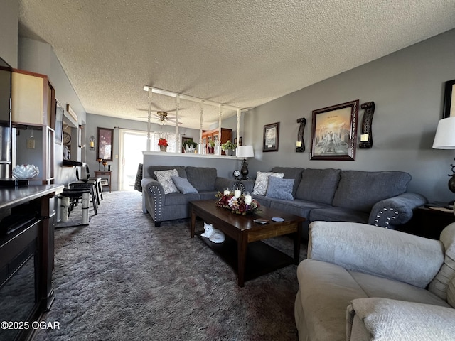 living area with a textured ceiling and dark colored carpet