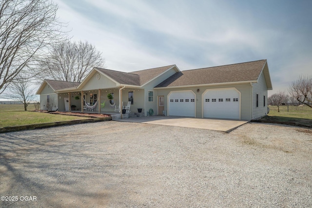 single story home with a garage, driveway, a porch, and a front lawn