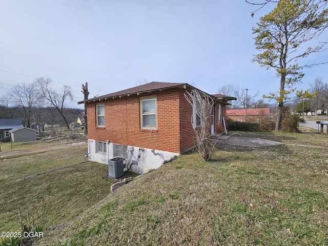 view of home's exterior with a patio, a lawn, brick siding, and central AC