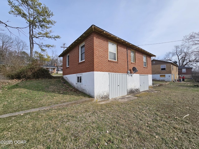 view of side of home featuring brick siding and a lawn