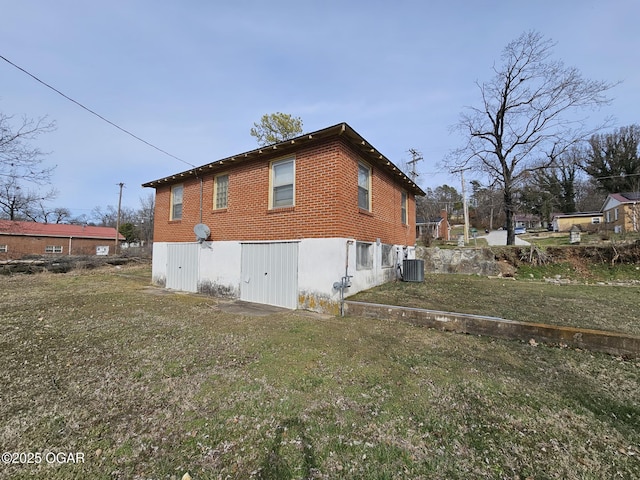 back of house featuring brick siding, central AC unit, and a lawn