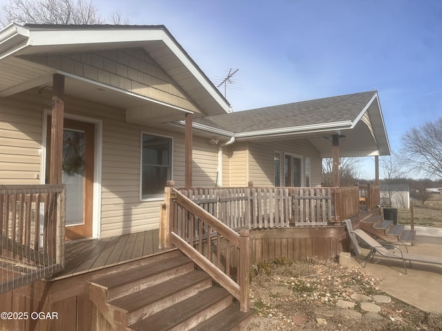 exterior space with a shingled roof and a wooden deck