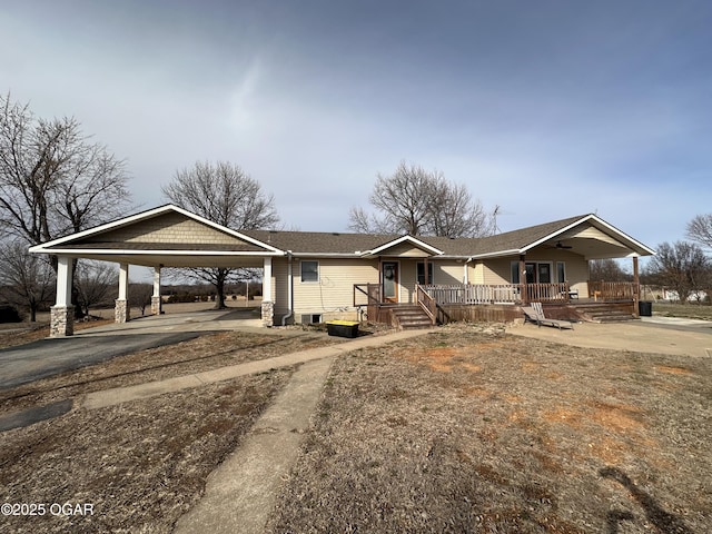 single story home featuring a carport, aphalt driveway, and a porch