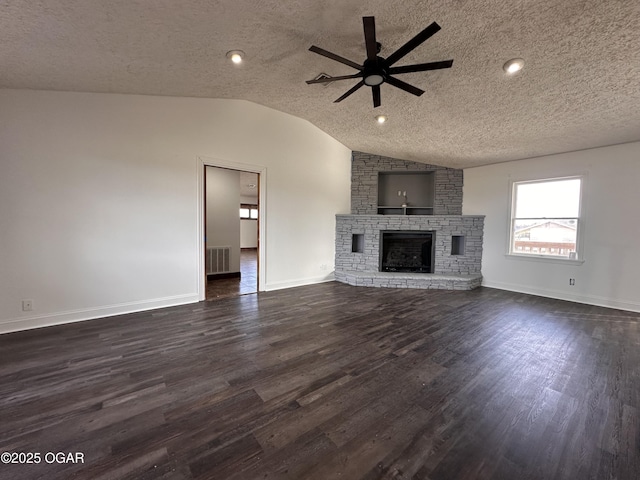 unfurnished living room featuring dark wood-style flooring, visible vents, vaulted ceiling, and a stone fireplace