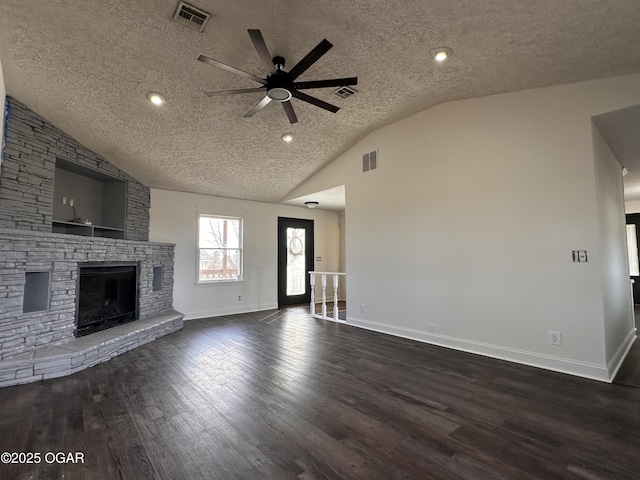 unfurnished living room with dark wood-style floors, lofted ceiling, visible vents, and a fireplace