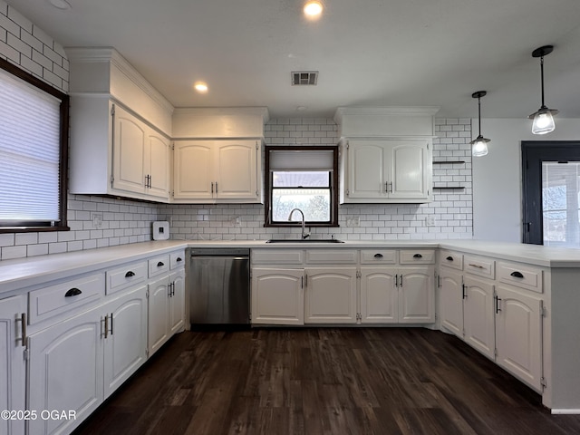 kitchen featuring a peninsula, dark wood-type flooring, a sink, visible vents, and stainless steel dishwasher