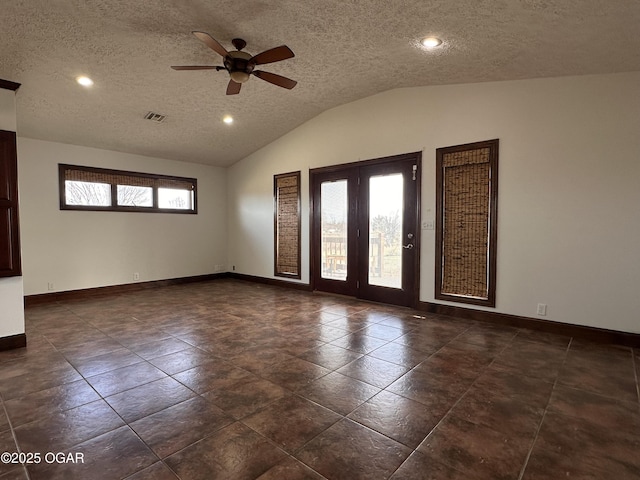 unfurnished room featuring baseboards, visible vents, lofted ceiling, ceiling fan, and a textured ceiling