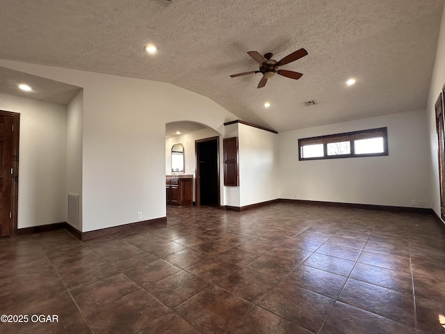 spare room featuring lofted ceiling, visible vents, and baseboards