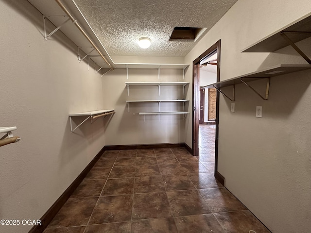 spacious closet with dark tile patterned flooring