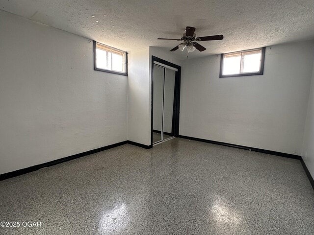 basement with a textured ceiling and baseboards