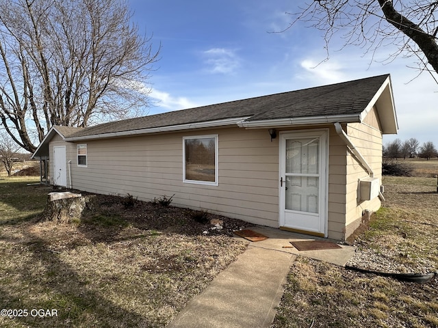 back of house with a shingled roof