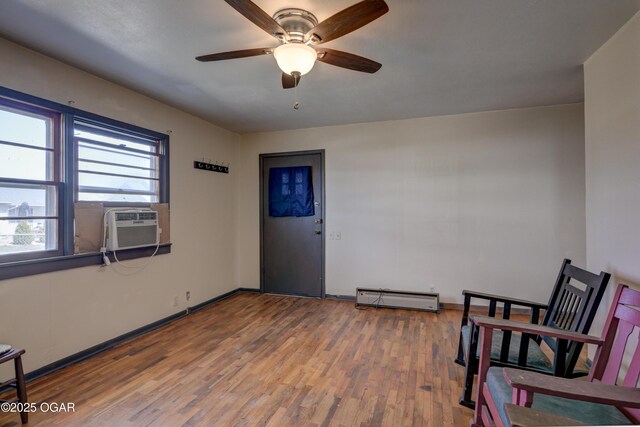 117 E Russell St, Goodman, MO 64843 - sitting room with cooling unit, wood finished floors, a ceiling fan, baseboards, and baseboard heating