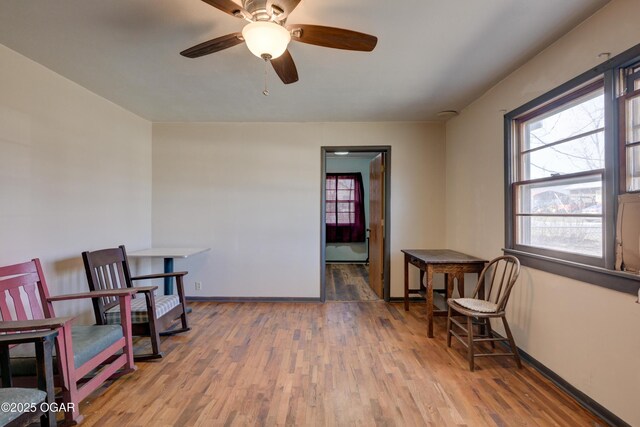 117 E Russell St, Goodman, MO 64843 - living area featuring ceiling fan, wood finished floors, and baseboards