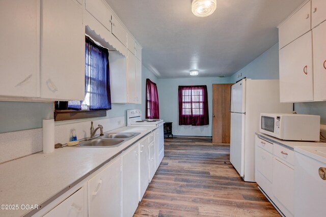117 E Russell St, Goodman, MO 64843 - kitchen with white microwave, wood finished floors, light countertops, a sink, and range with electric stovetop