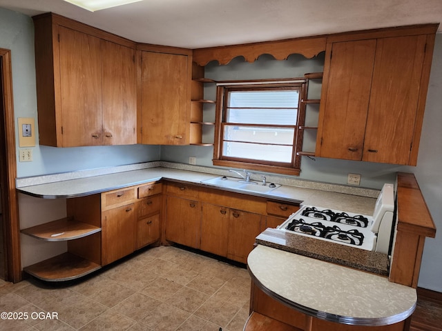 kitchen with brown cabinets, open shelves, a sink, and light countertops