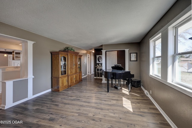 home office with a sink, baseboards, dark wood finished floors, and a textured ceiling