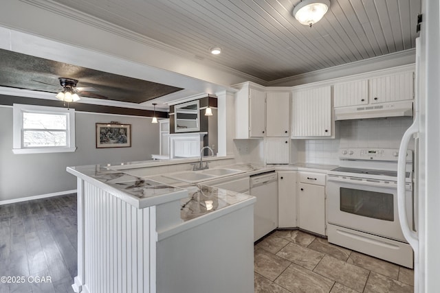 kitchen featuring decorative backsplash, white cabinetry, a sink, white appliances, and under cabinet range hood