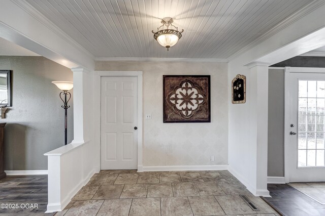 entryway featuring decorative columns, visible vents, baseboards, and crown molding