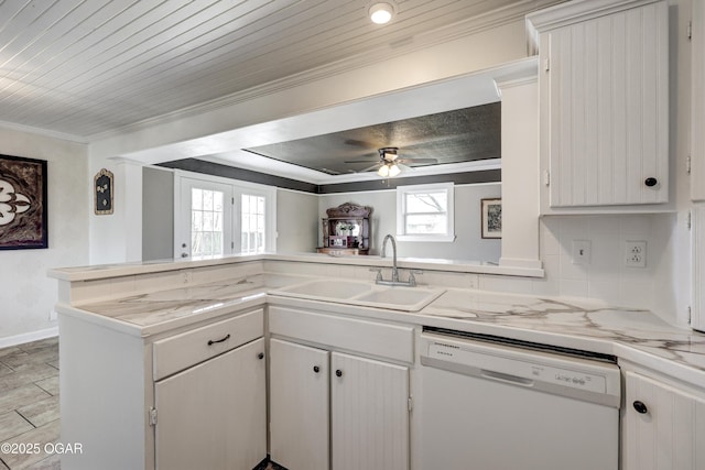 kitchen featuring a sink, light countertops, decorative backsplash, dishwasher, and crown molding