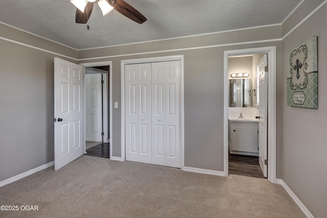 unfurnished bedroom with carpet floors, a closet, baseboards, and a textured ceiling