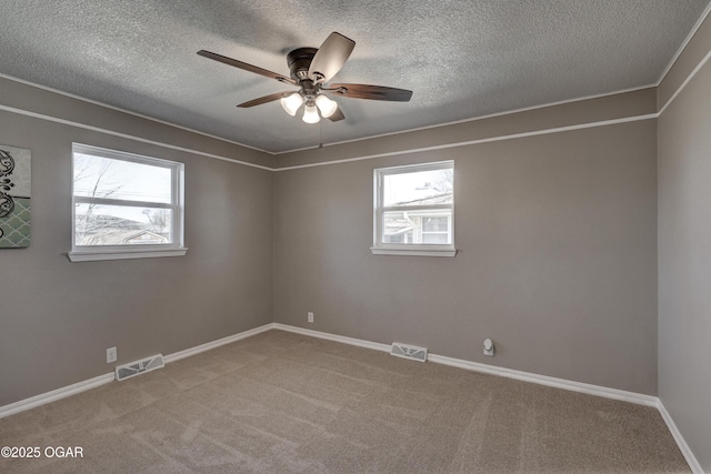 spare room featuring carpet, visible vents, and baseboards